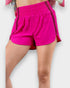Bright pink athletic shorts worn by a person on a white background