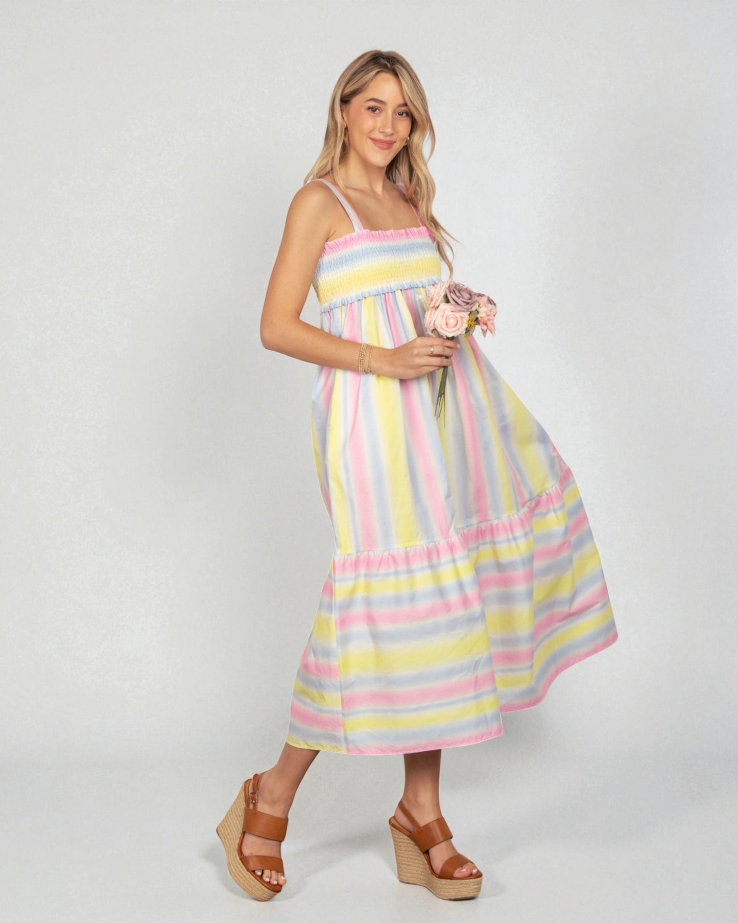 Woman wearing a colorful striped dress on a white background