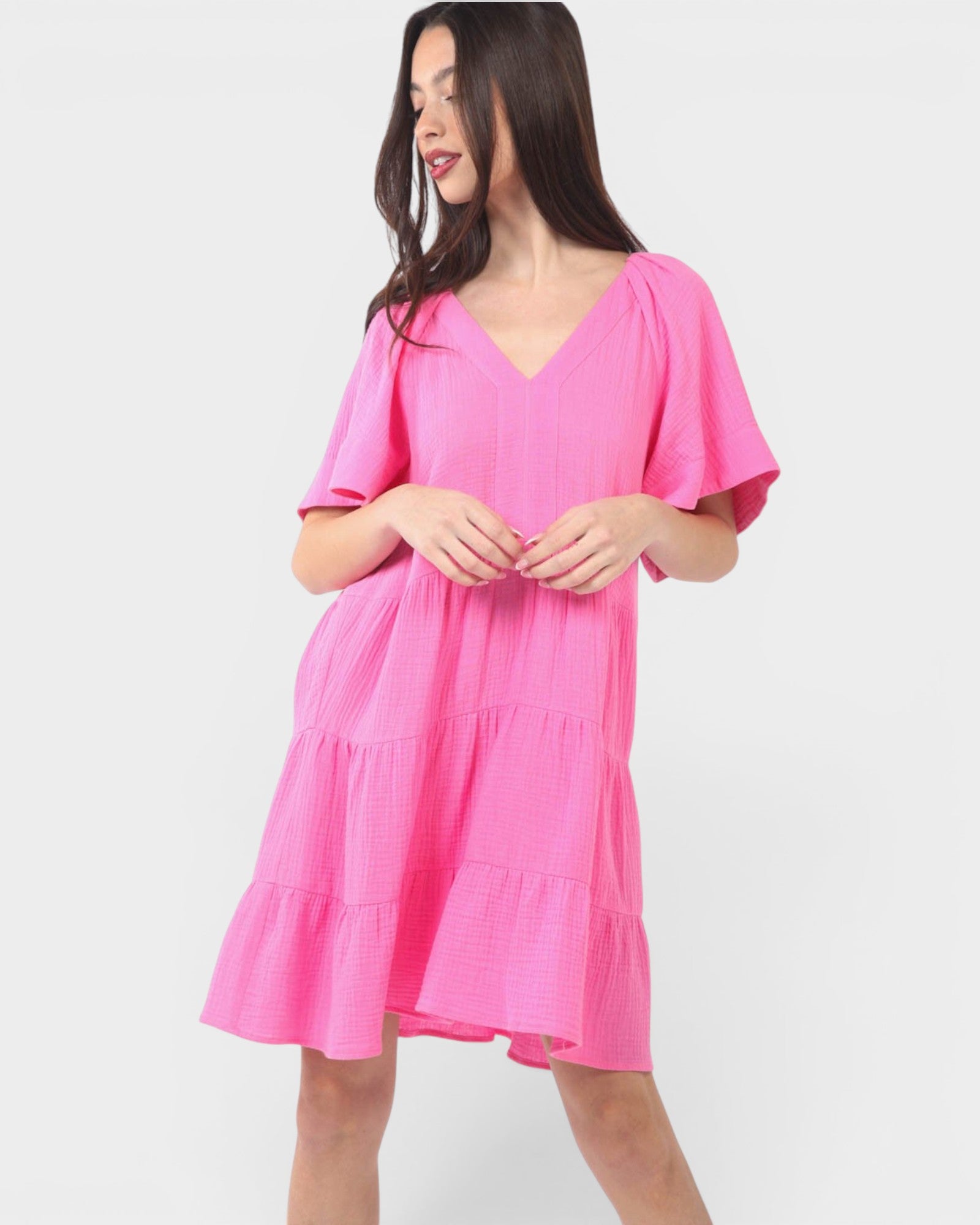 Woman wearing a bright pink dress on a white background