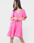 Woman wearing a bright pink dress on a white background