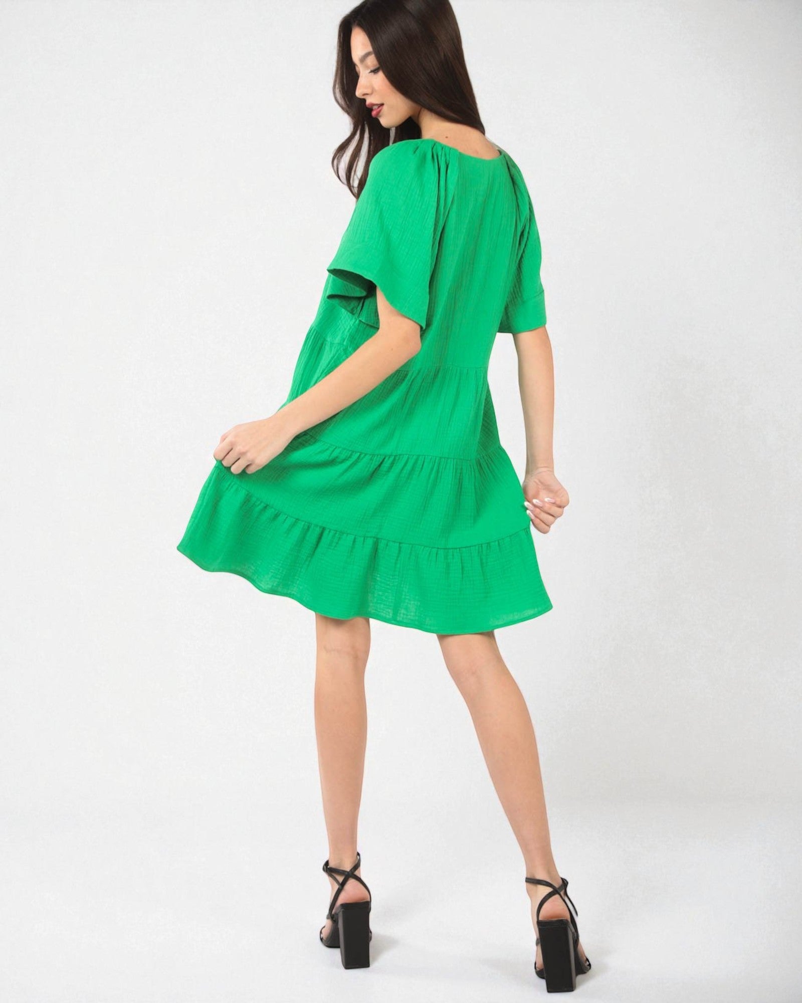 Green dress worn by a model on a white background