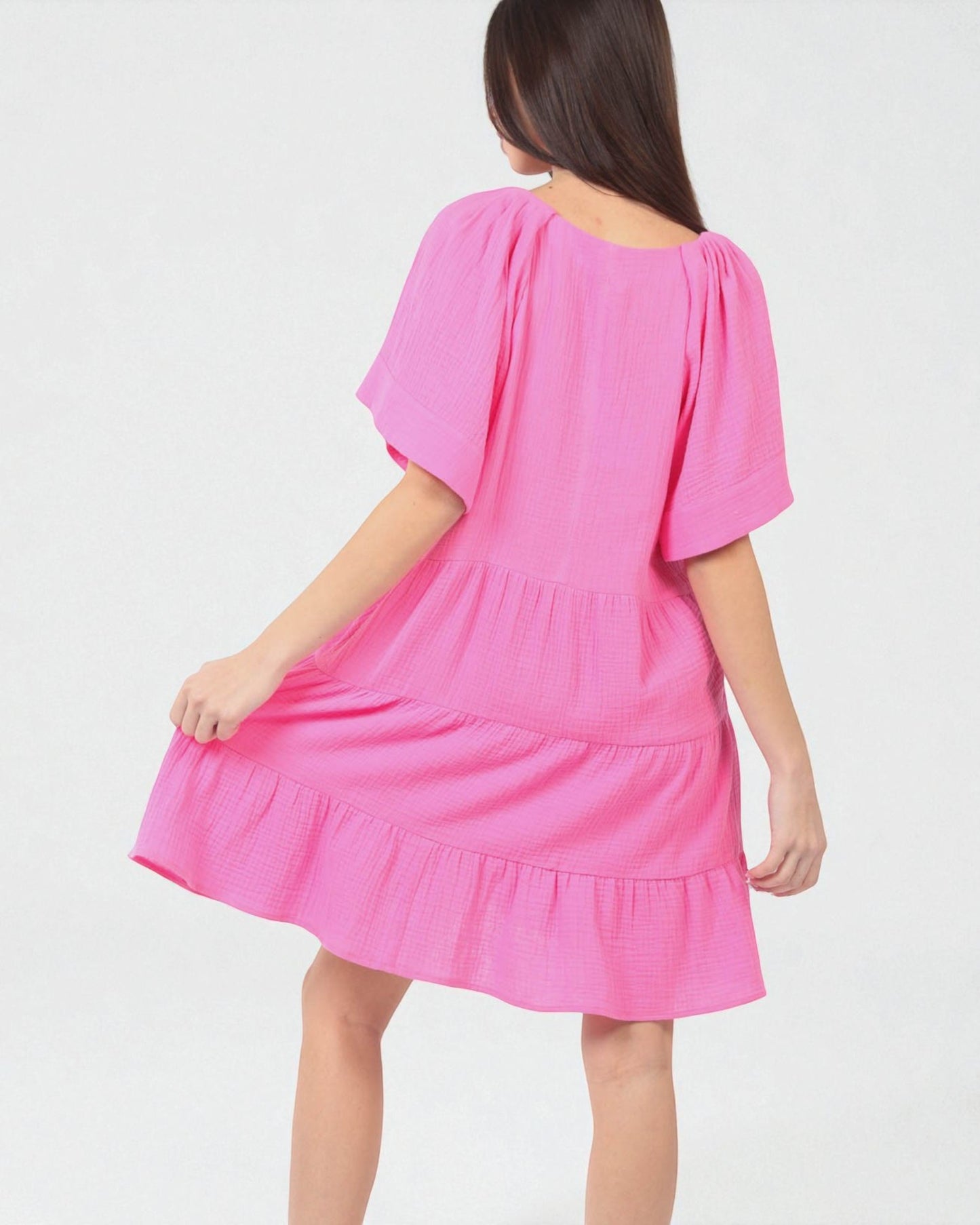 Pink dress worn by a person on a white background