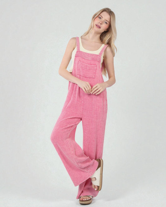 Woman wearing a pink jumpsuit on a white background