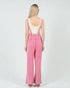 Person wearing pink checkered overalls on a white background