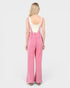 Person wearing pink checkered overalls on a white background