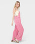 Woman wearing pink checkered overalls on a white background