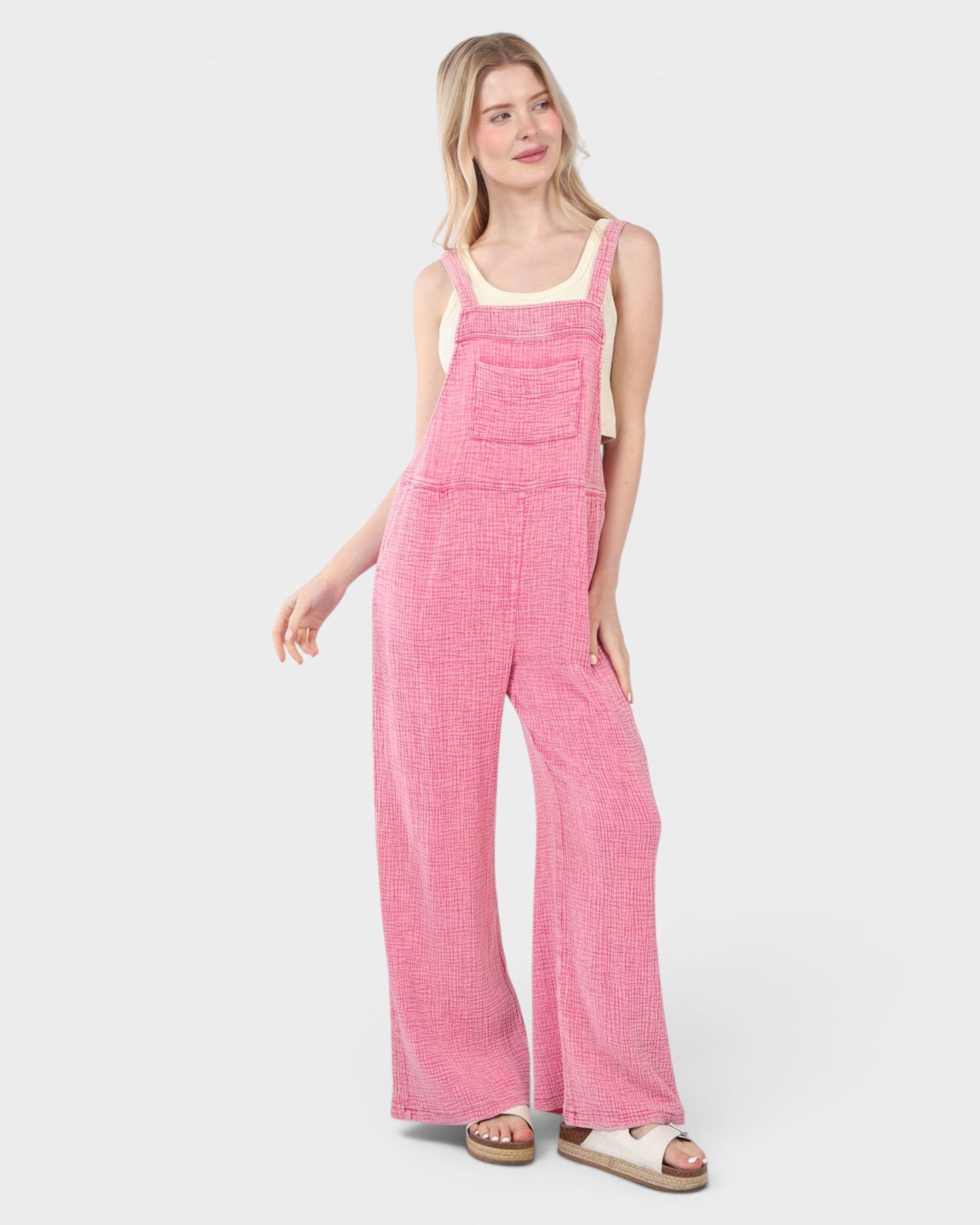 Woman wearing pink checkered overalls on a white background