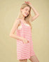 Woman wearing a pink striped dress against a beige background