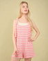 Woman wearing a pink and white striped dress against a beige background