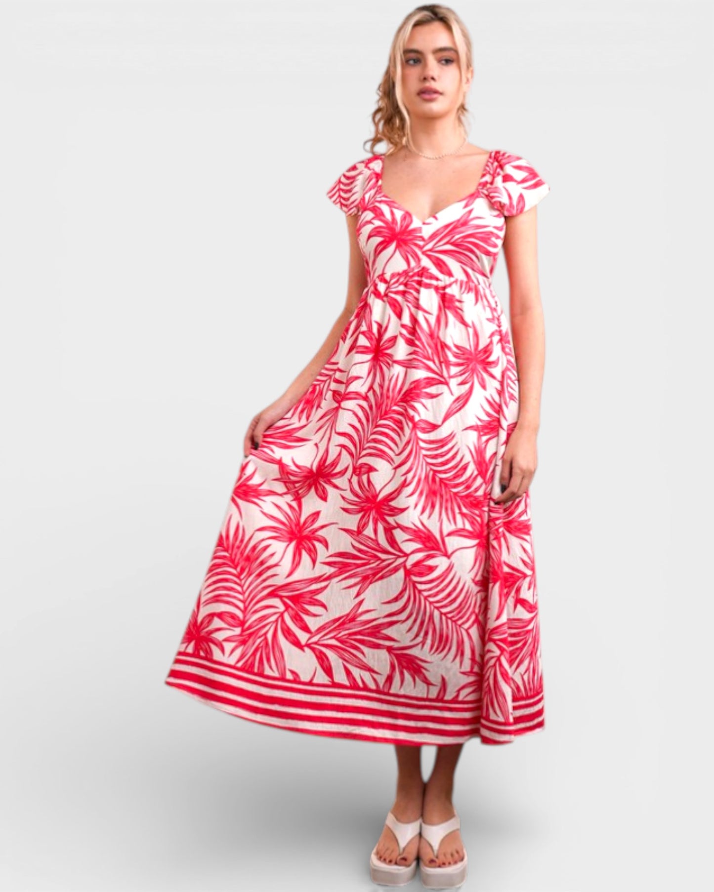 Woman wearing a red and white floral dress on a light gray background