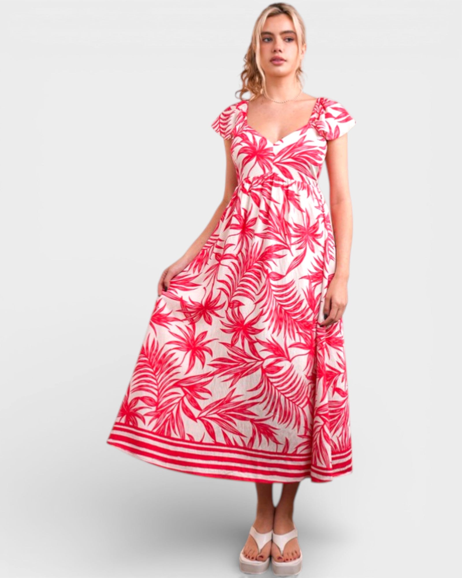 Woman wearing a red and white floral dress on a light gray background