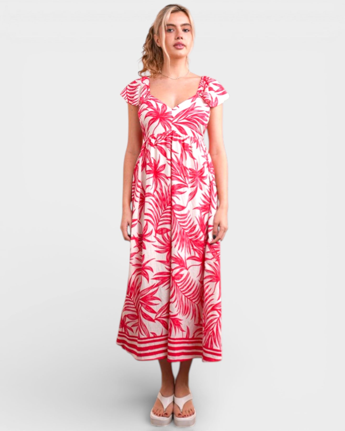 Woman wearing a pink and white floral dress on a white background
