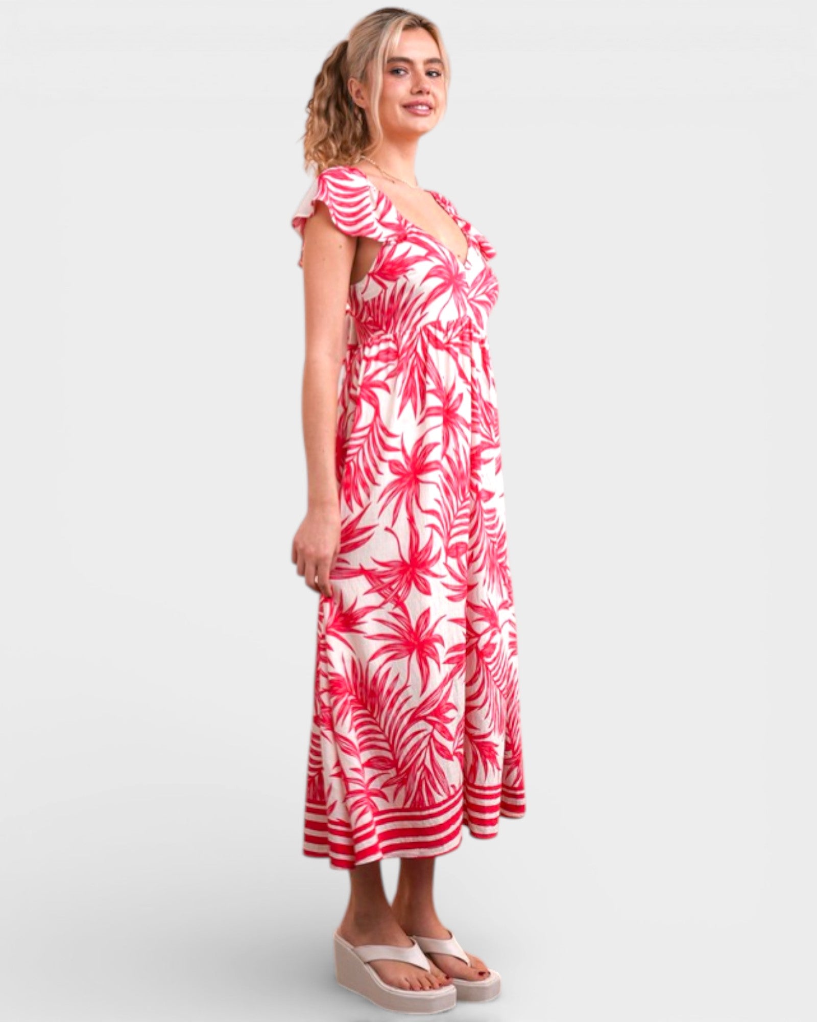 Woman wearing a red and white floral dress on a white background