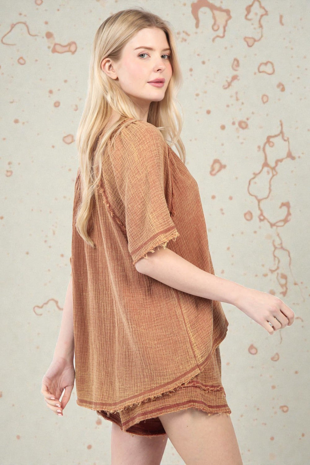 Woman wearing a brown textured dress against a light background