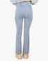 A person shown from the back wearing light-wash blue flared jeans, a multicolor knit top, and beige platform shoes against a plain light gray background.