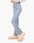 A person wearing light-wash blue jeans and beige chunky platform boots, shown from the waist down against a plain light gray studio background.