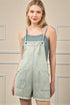 Woman wearing a light denim overalls with a beige background