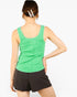 A woman shown from the back wearing a bright green sleeveless tank top and dark brown shorts against a plain light gray studio background.