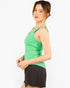 A woman wearing a bright green sleeveless athletic tank top and dark brown shorts, shown from a side profile against a plain white studio background.