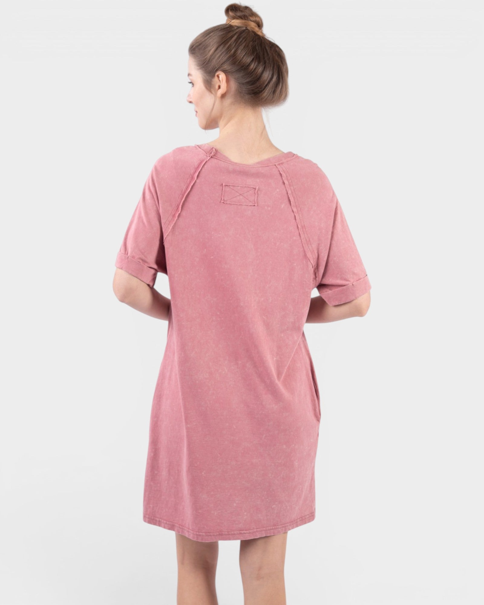 Person wearing a pink dress on a white background