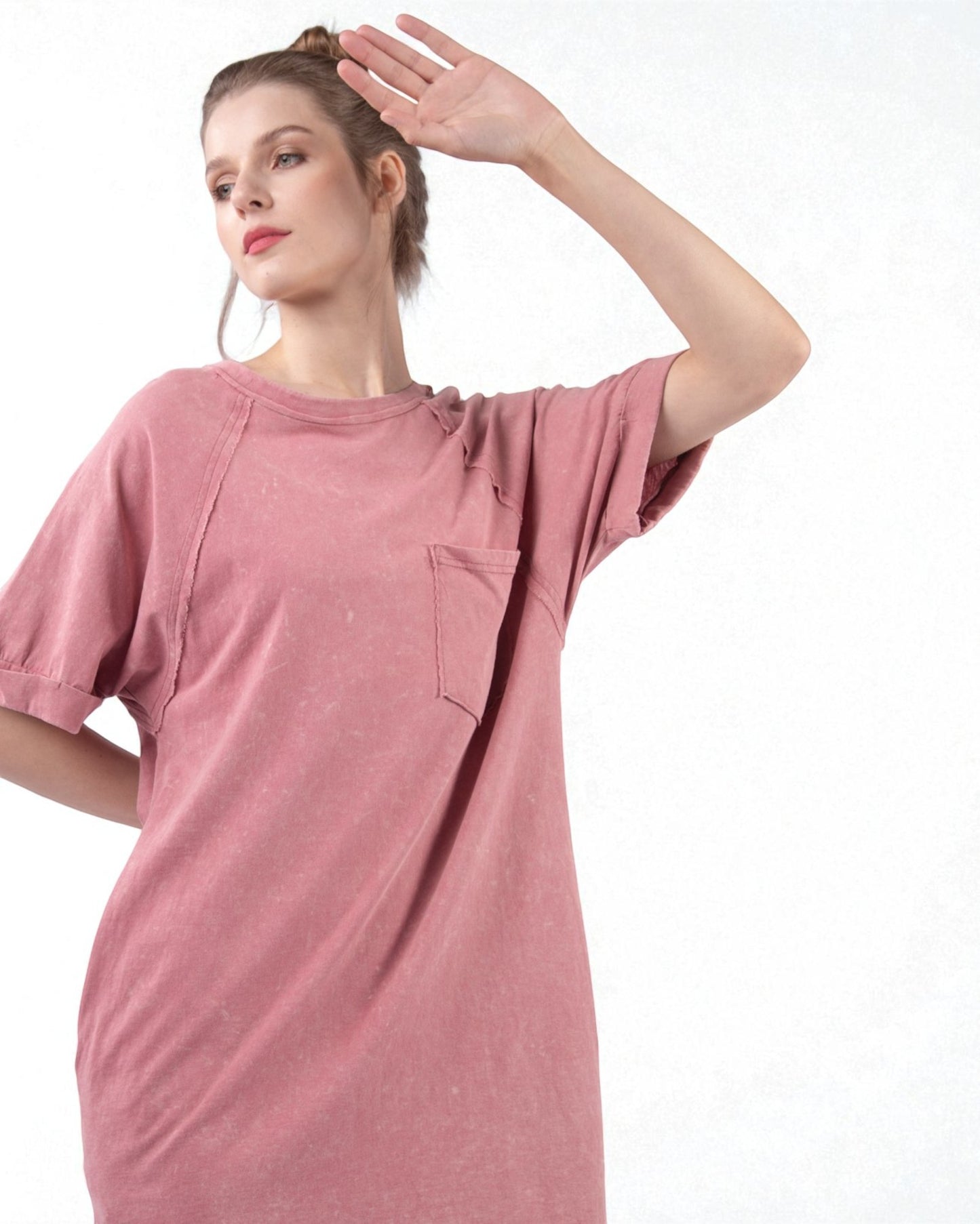 Woman wearing a pink dress with a plain background