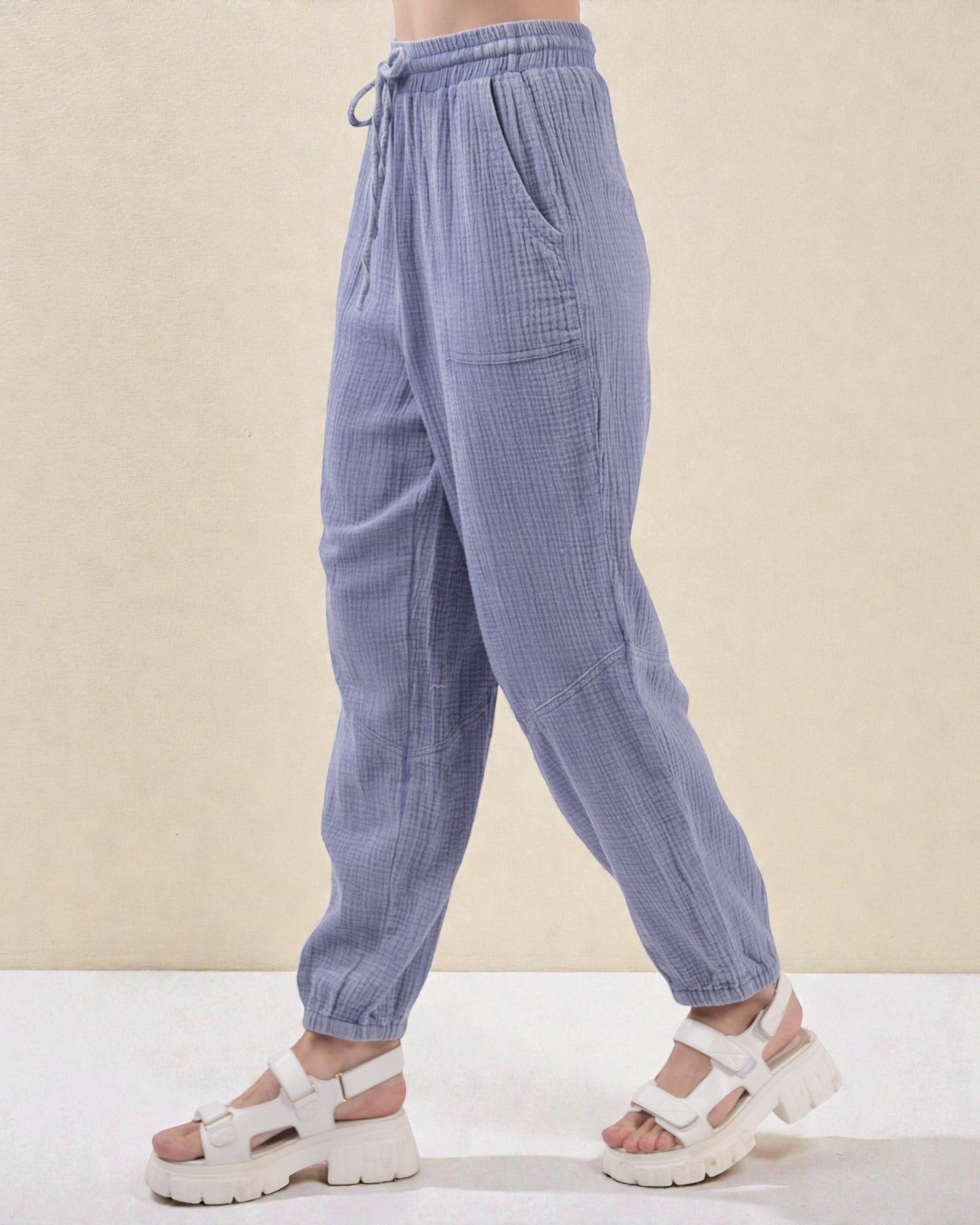 Blue corduroy pants worn by a person on a beige background
