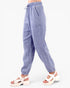 A person wearing loose, light blue-gray textured drawstring pants with side pockets and white platform sandals, shown from the waist down against a plain light background.