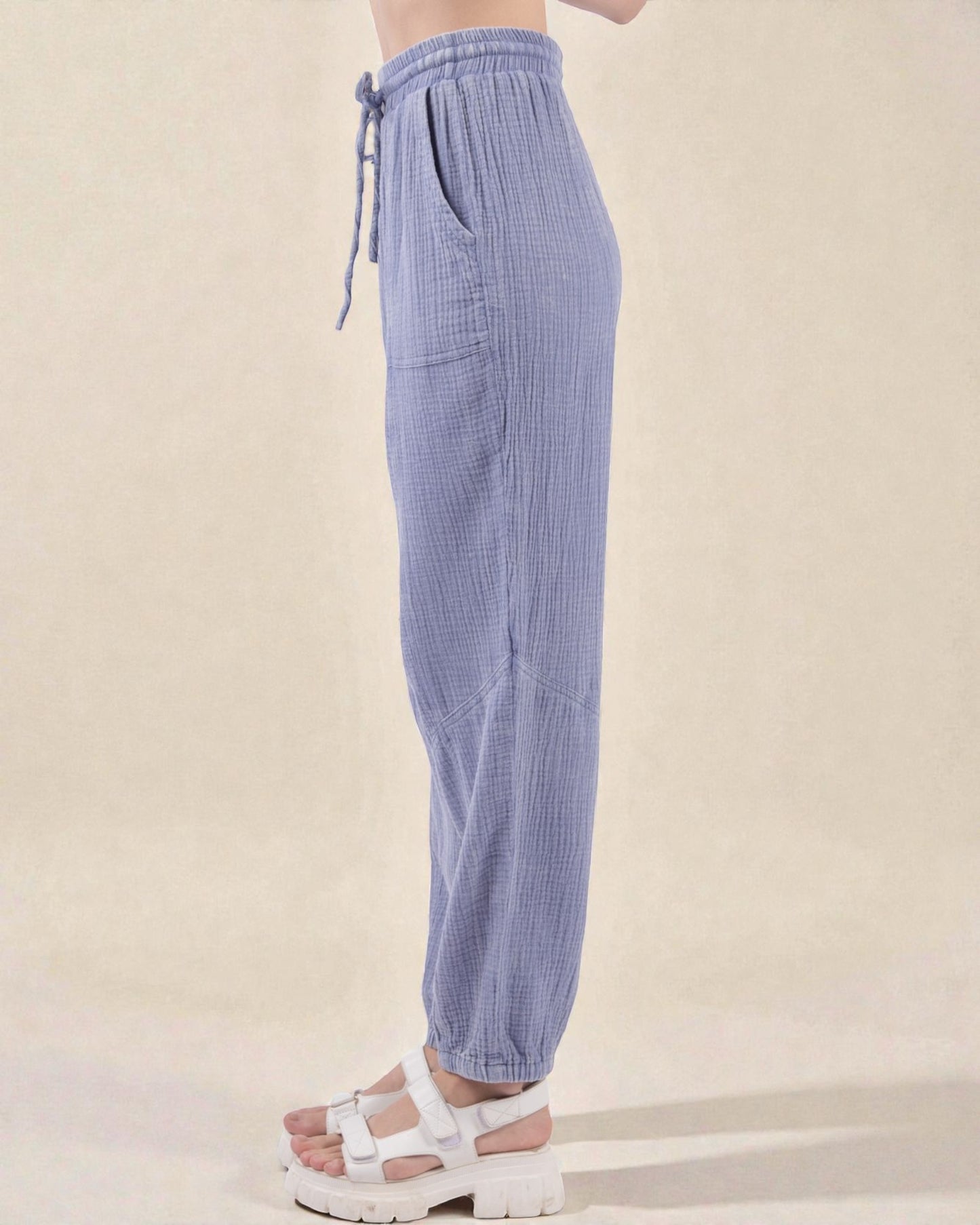 Blue checkered pants worn by a person on a beige background