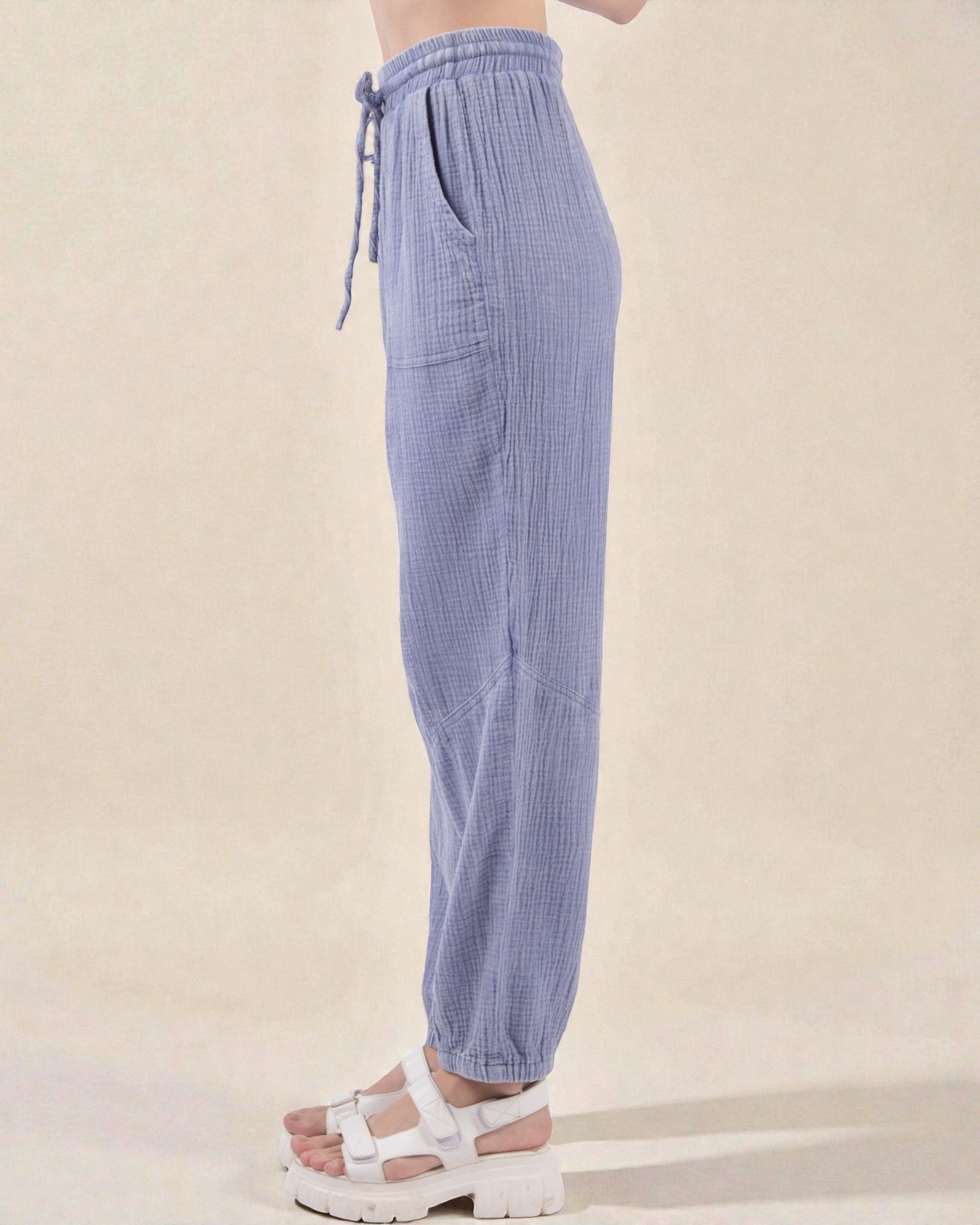 Blue checkered pants worn by a person on a beige background