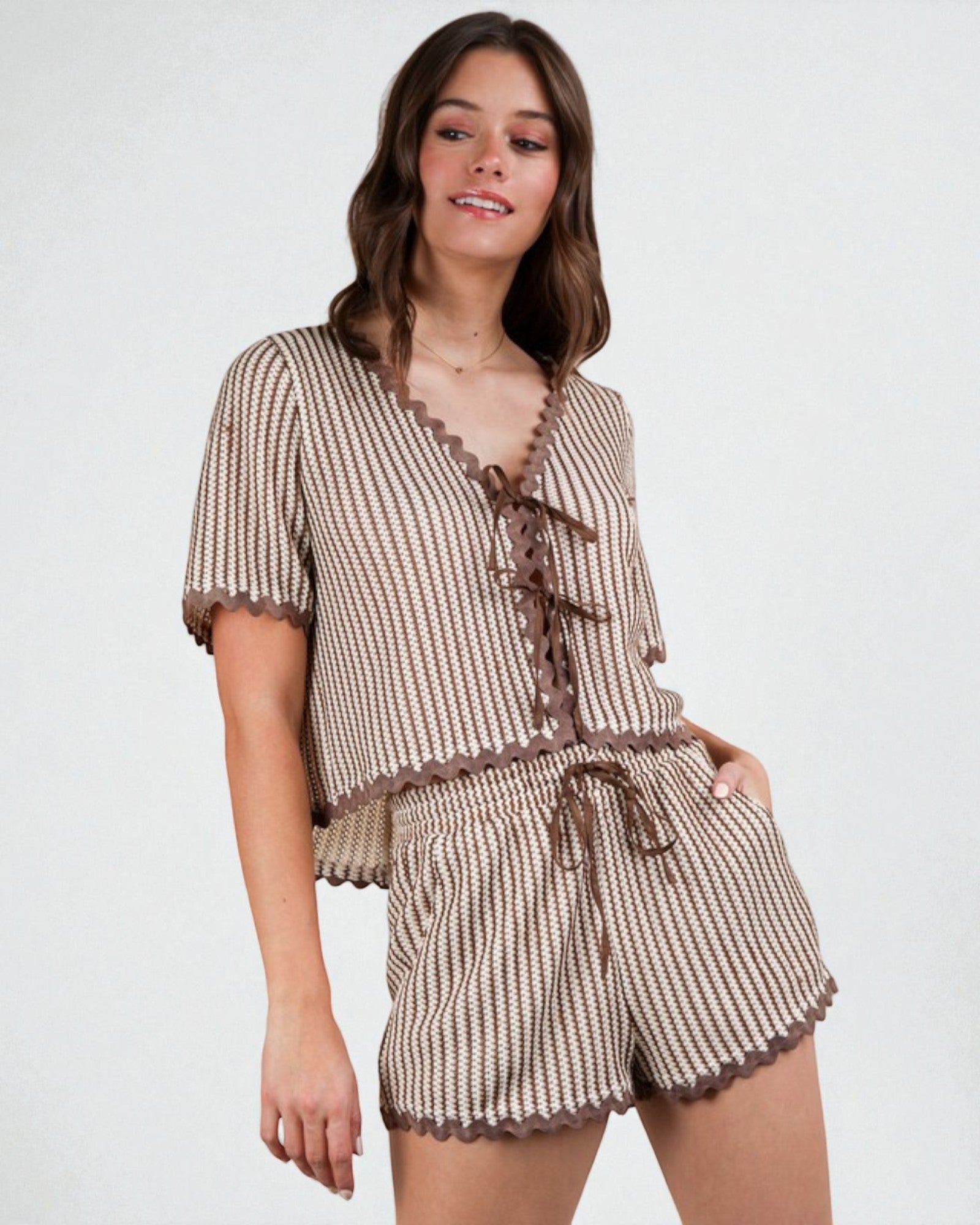 Woman wearing a patterned outfit with lace details on a white background