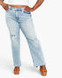 A model wearing light-wash blue distressed jeans with a straight-leg fit, frayed hems, and ripped details on the thighs, paired with brown platform sandals against a plain white background.