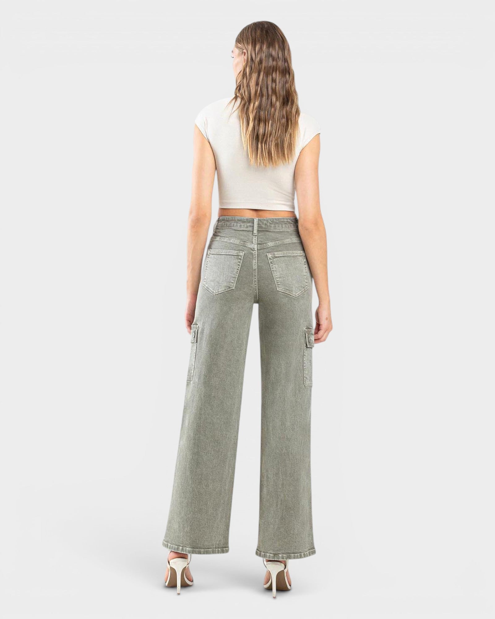 Woman wearing green wide-leg jeans on a white background