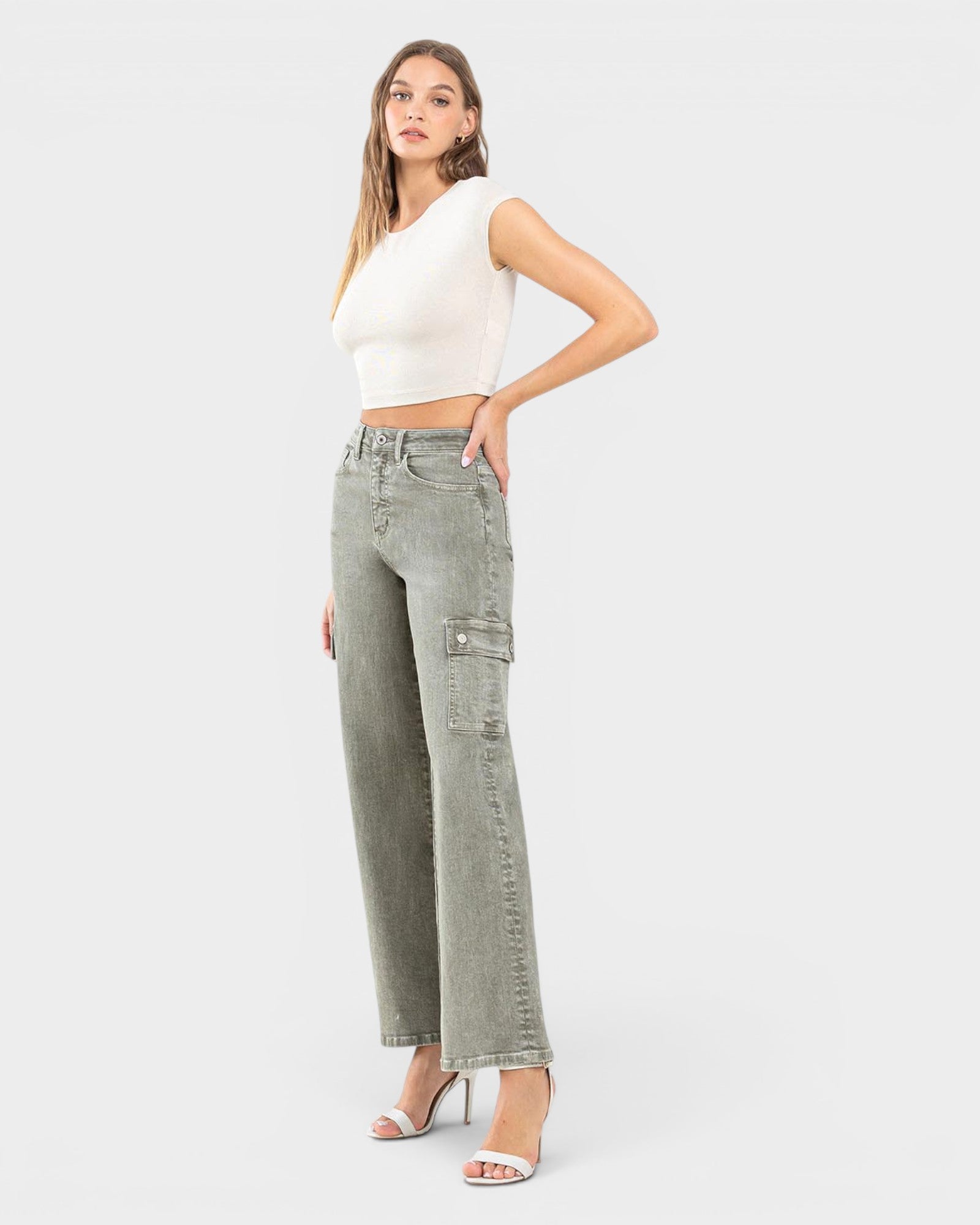 Woman wearing a white top and light gray cargo pants on a white background