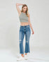 Woman wearing a crop top and jeans on a plain background