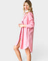 Woman wearing a pink shirt dress on a white background