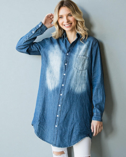 Woman wearing a blue denim shirt with a white wall background