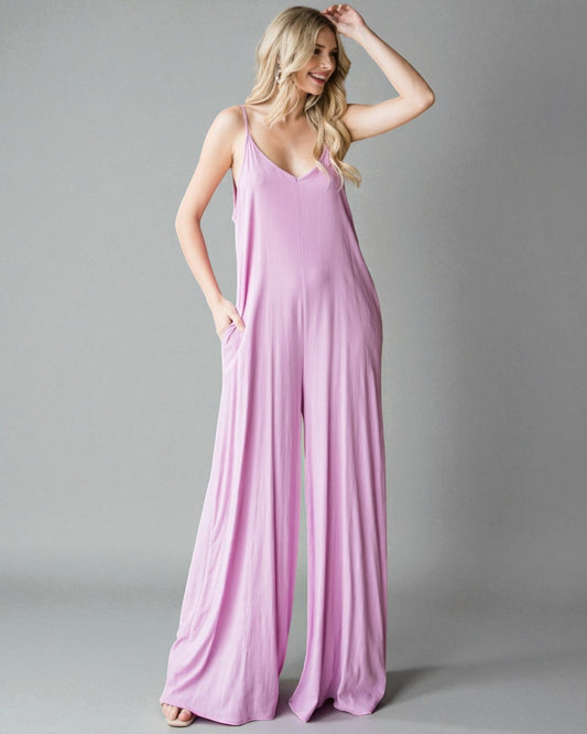 Woman wearing a pink jumpsuit against a gray background