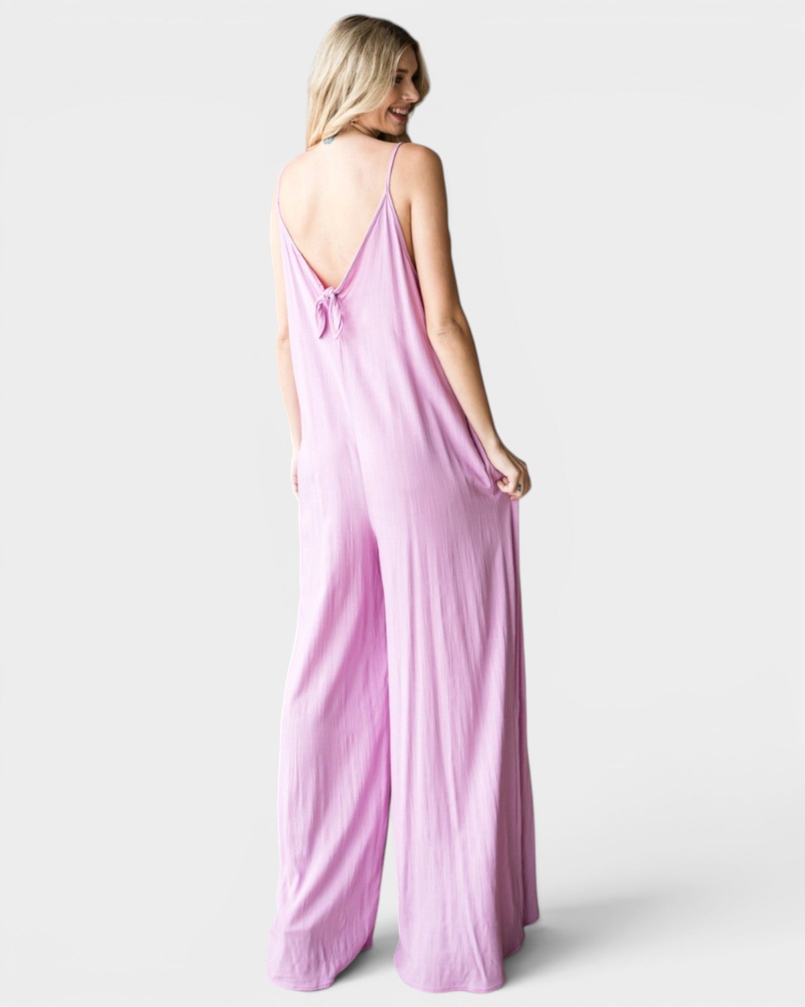 Woman wearing a pink jumpsuit on a white background