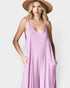 Woman wearing a pink dress and straw hat on a white background