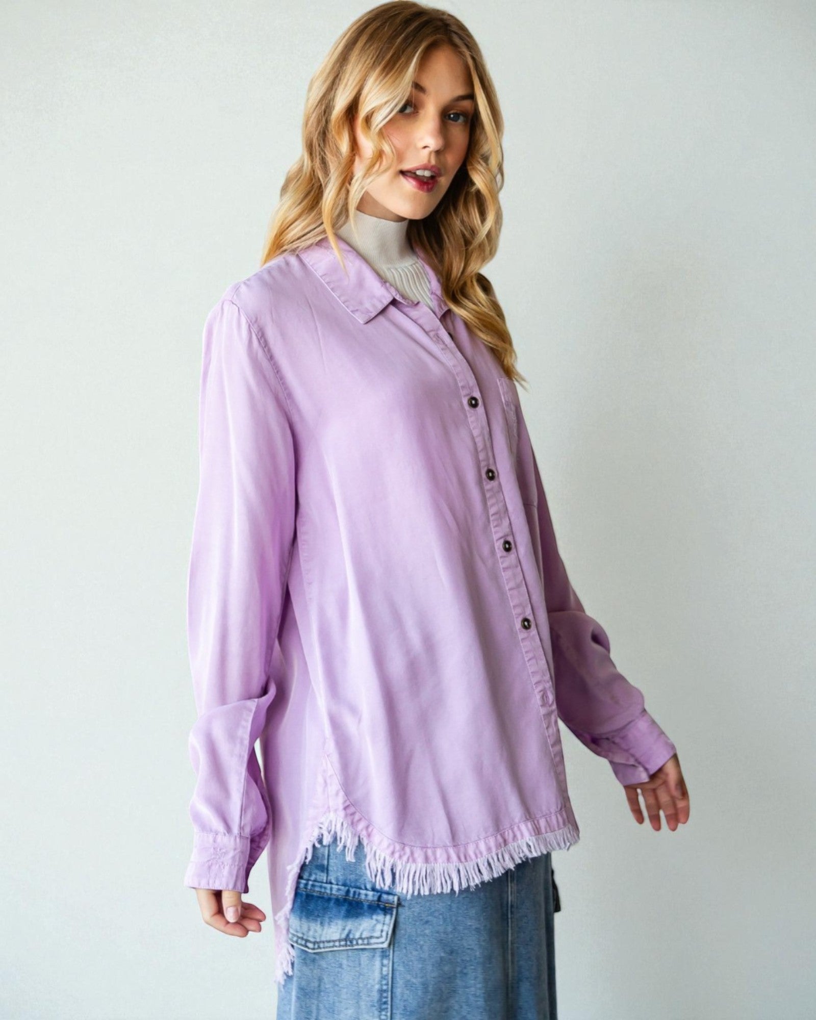 Woman wearing a light purple button-up shirt with a white background