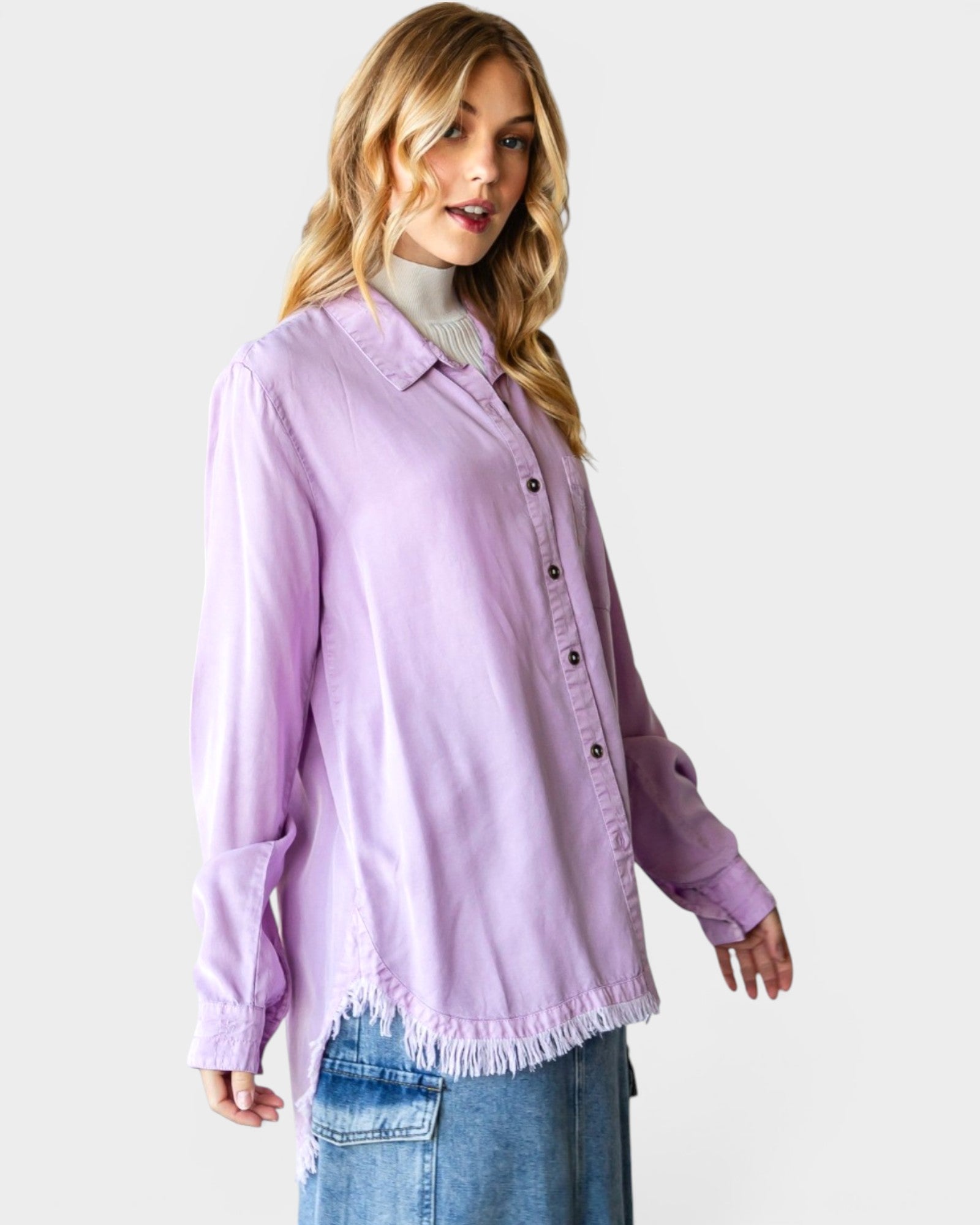 Woman wearing a light purple denim shirt with frayed hems on a white background