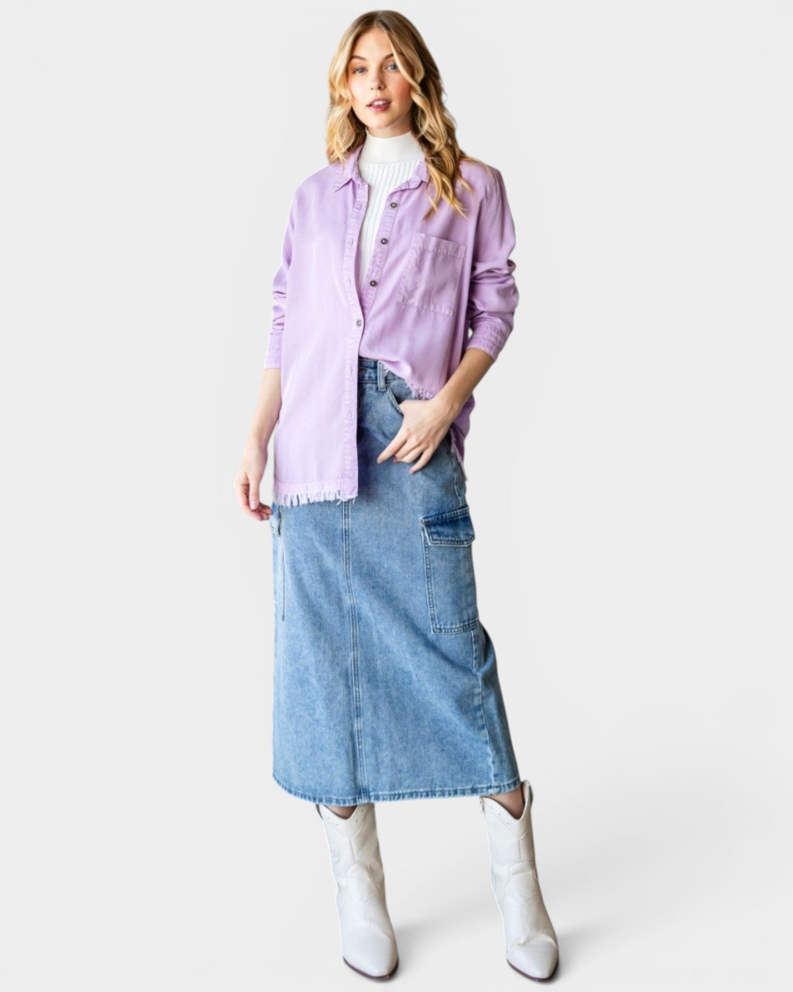 Woman wearing a light purple shirt, denim skirt, and white boots on a white background