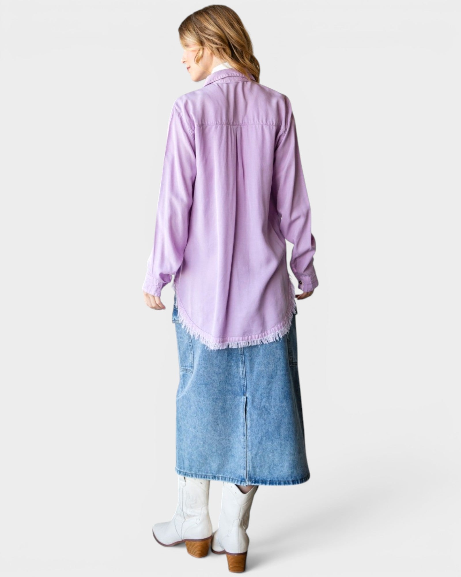 Woman wearing a light purple shirt and blue denim skirt on a white background