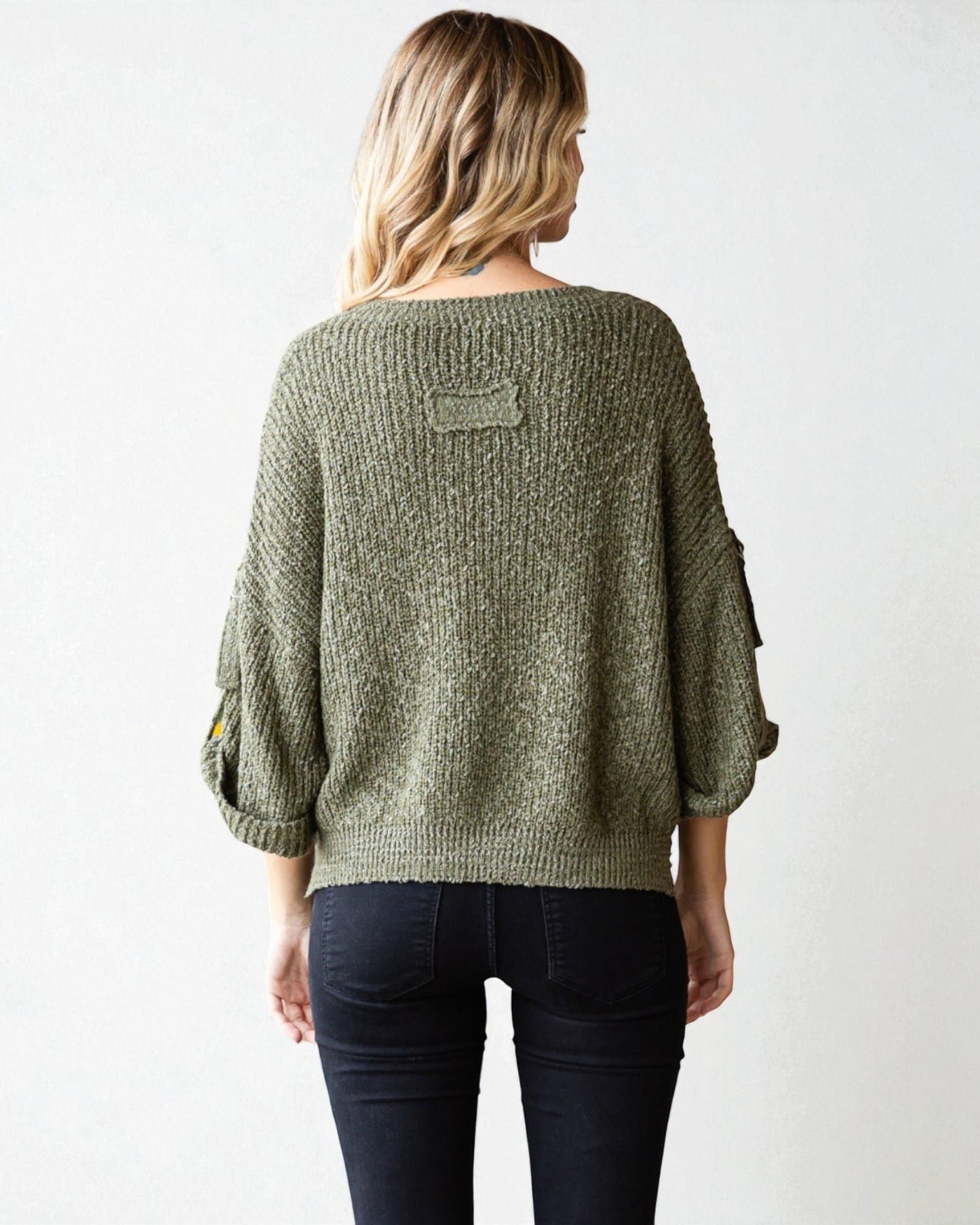 Woman wearing a green sweater with a white background