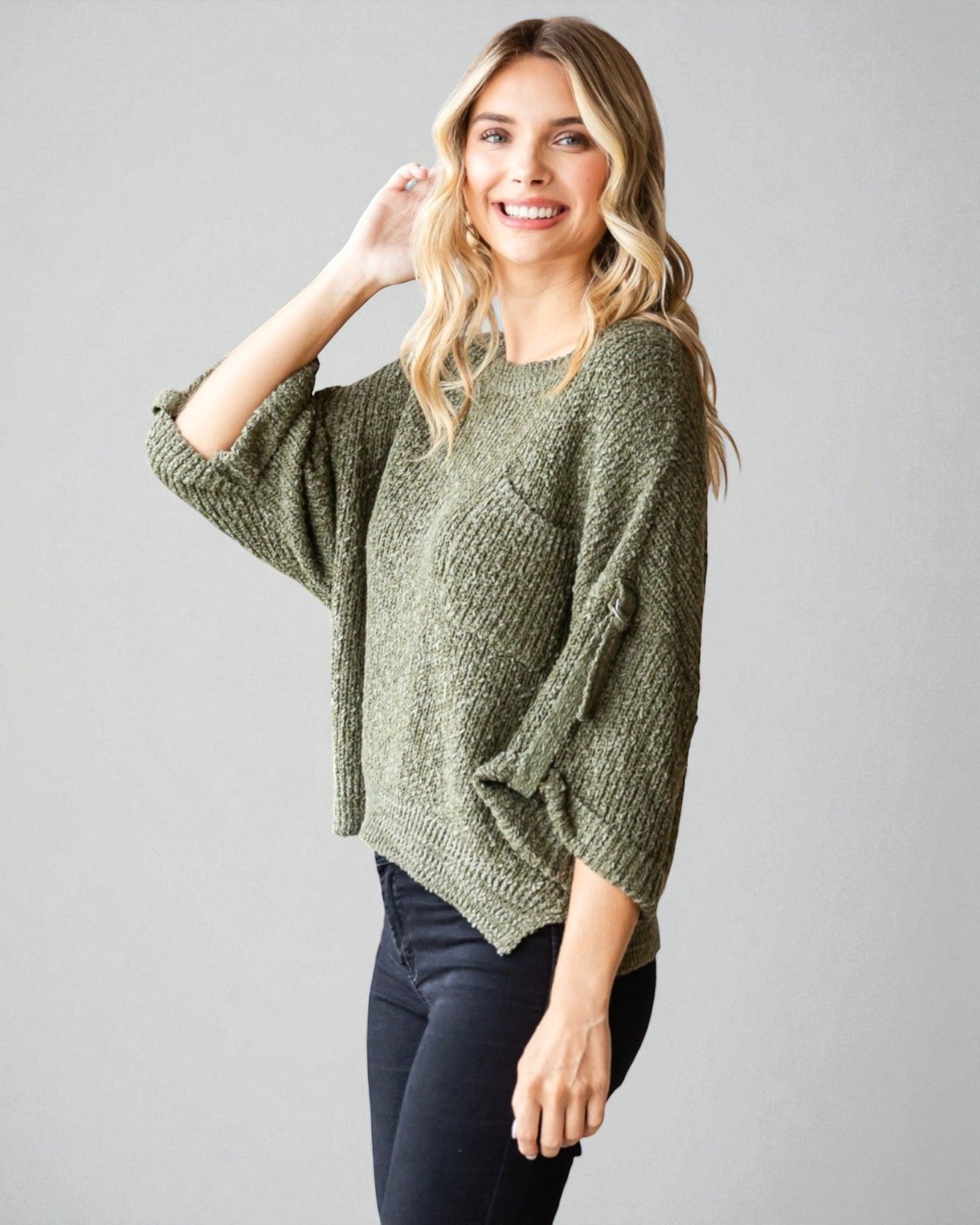 Woman wearing a green sweater against a gray background