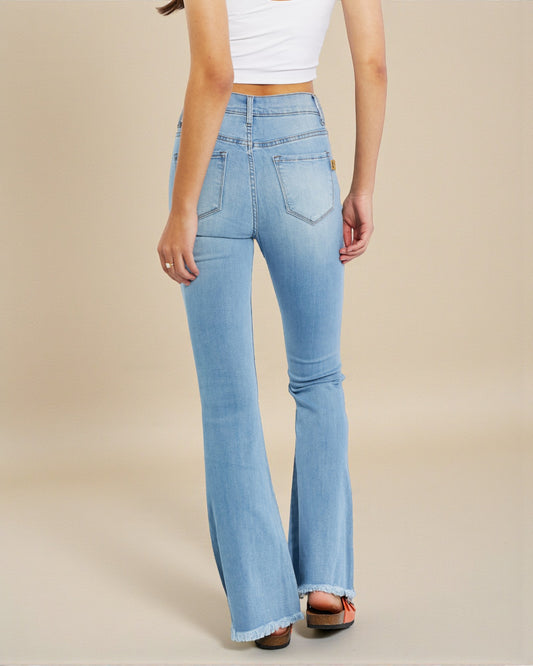 Light blue flared jeans worn by a person on a beige background