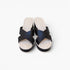 A pair of women's platform slide sandals with wide black crisscross straps and a thick cream-colored platform sole, shown from a top-down view on a light gray background.