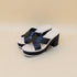 Black and white platform sandals on a beige background