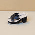 Black platform sandals with white sole on a beige background