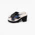 A pair of women's platform mule sandals with wide crisscross straps in a dark navy satin-like finish, set against a clean white background.